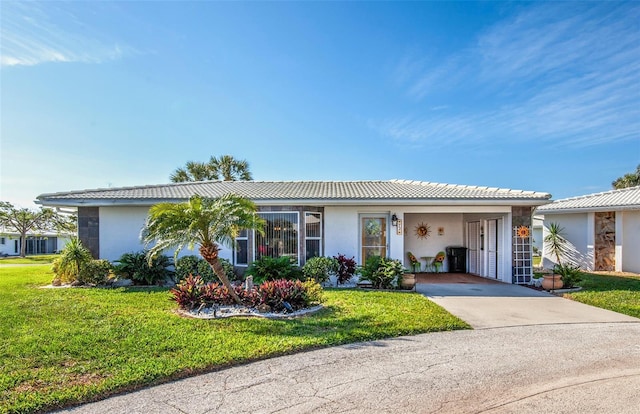 ranch-style house with concrete driveway, a front lawn, and stucco siding