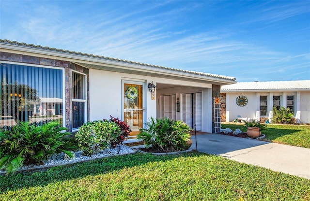 view of front of property featuring a front lawn and stucco siding