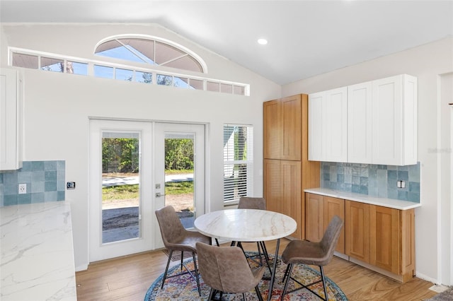 dining area with light wood-style floors, recessed lighting, french doors, and vaulted ceiling