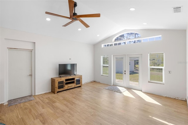 living area featuring lofted ceiling, french doors, plenty of natural light, and light wood-style floors