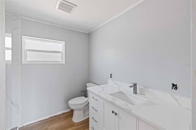 bathroom featuring toilet, wood finished floors, vanity, and visible vents