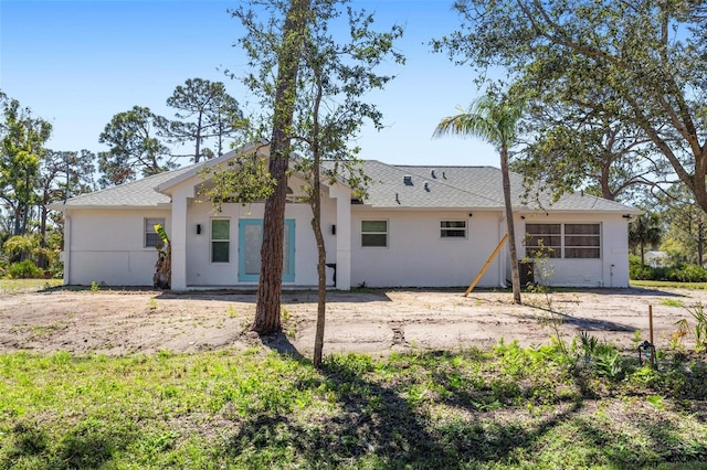 back of property featuring stucco siding