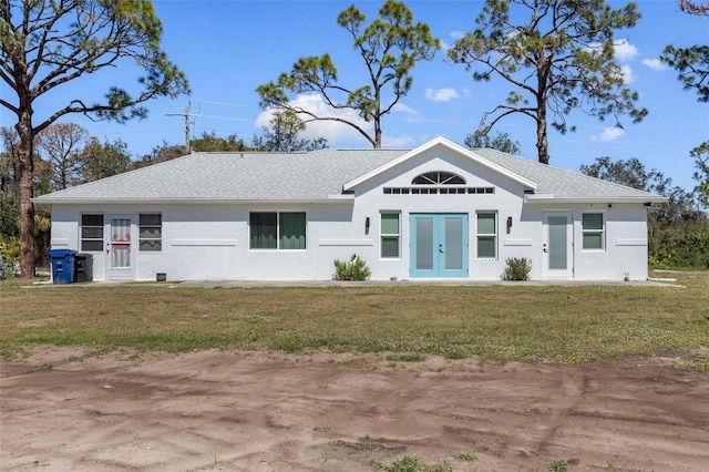 ranch-style house with roof with shingles, french doors, a front lawn, and stucco siding