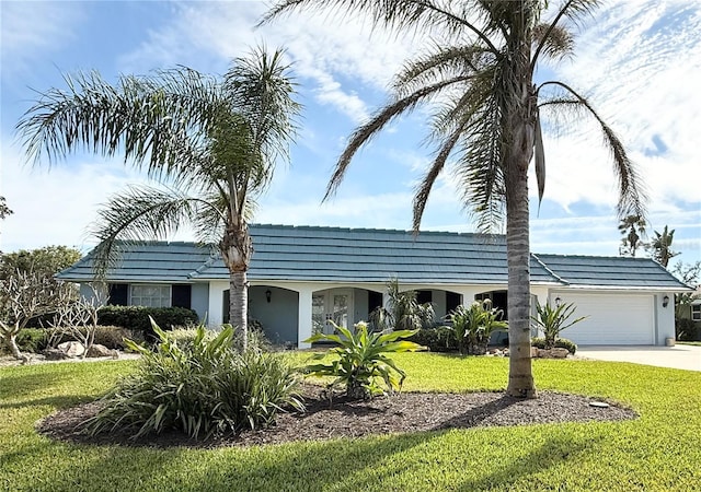 view of front facade with a garage, concrete driveway, a front lawn, and stucco siding