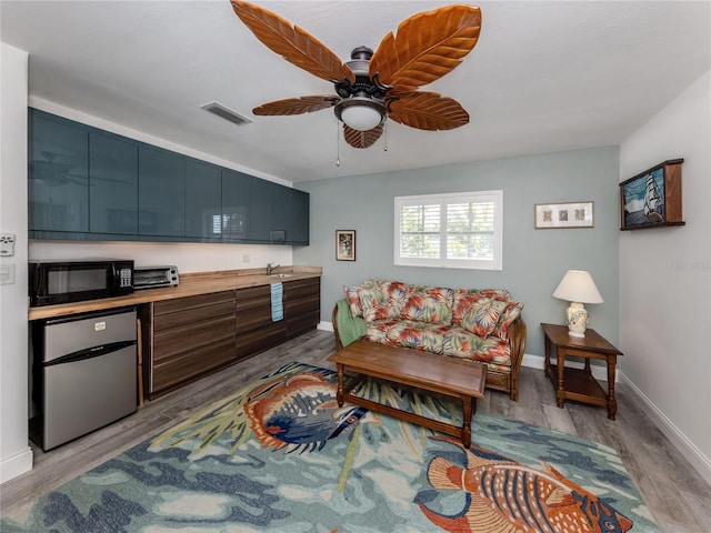 601 Apalachicola Rd, Venice, FL 34285 - living area with ceiling fan, light wood-style flooring, and baseboards