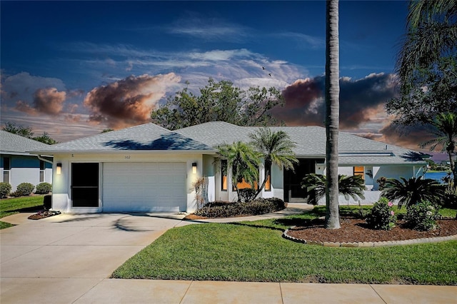 ranch-style home featuring driveway, roof with shingles, an attached garage, a front lawn, and stucco siding