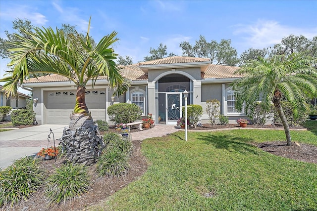 mediterranean / spanish-style house with an attached garage, a front yard, concrete driveway, and a tiled roof