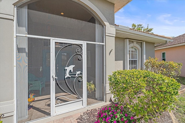 doorway to property featuring stucco siding