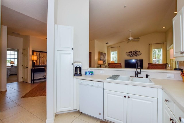 kitchen featuring light tile patterned floors, light countertops, vaulted ceiling, white dishwasher, and a sink