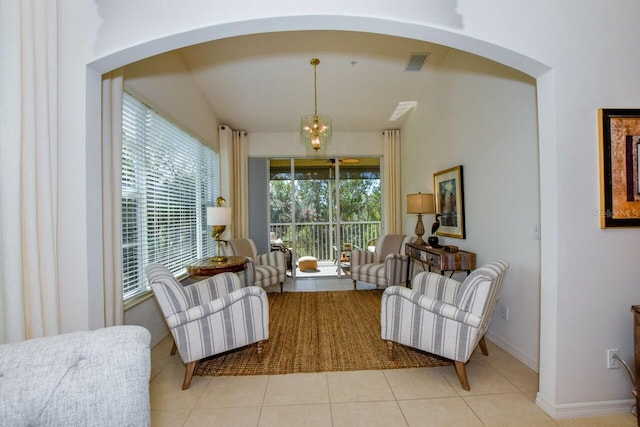 living area with baseboards, tile patterned flooring, visible vents, and a wealth of natural light