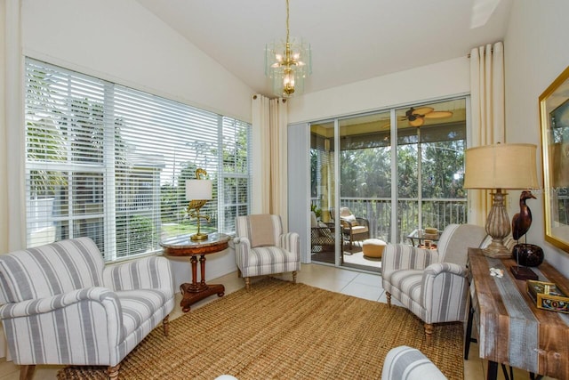 sunroom featuring vaulted ceiling and ceiling fan with notable chandelier