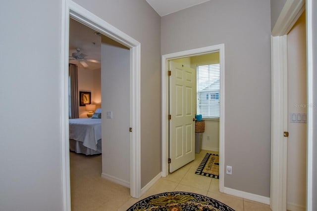 corridor with baseboards and light tile patterned floors