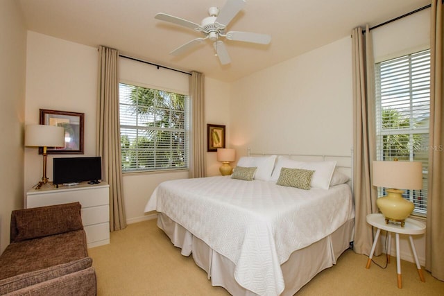 bedroom with a ceiling fan and light colored carpet