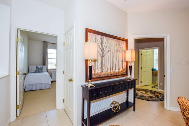 corridor featuring baseboards and light tile patterned flooring