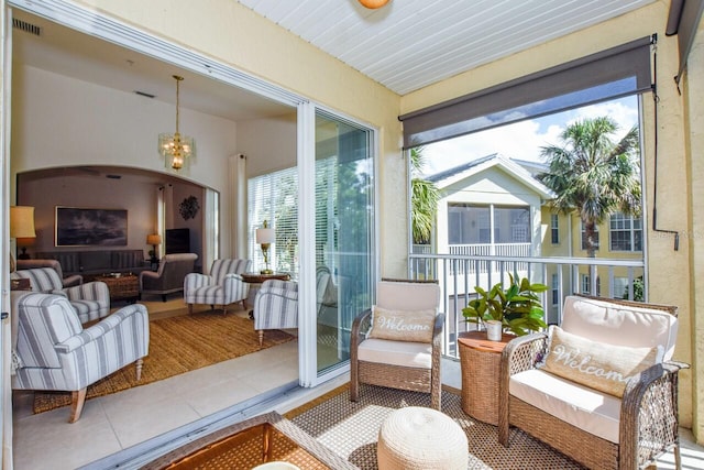 sunroom / solarium featuring a chandelier, arched walkways, and visible vents