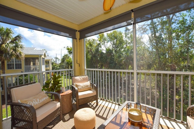 sunroom / solarium featuring a ceiling fan