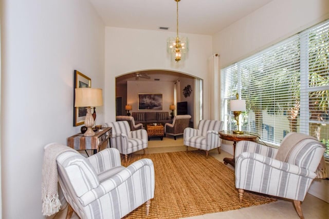 sitting room with arched walkways, visible vents, and a notable chandelier