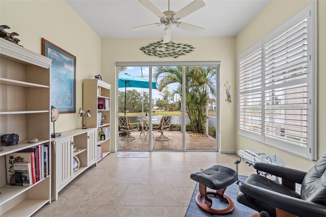 living area with light tile patterned floors and ceiling fan