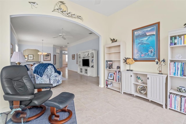 living room with light tile patterned floors, arched walkways, a ceiling fan, and ornamental molding