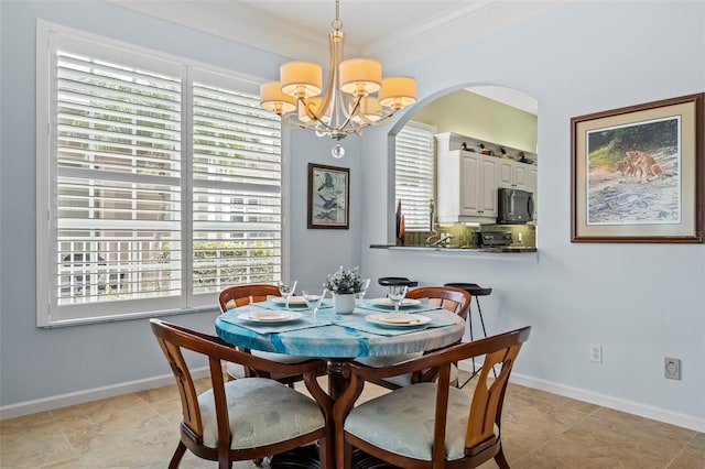 dining space with a notable chandelier, baseboards, and crown molding