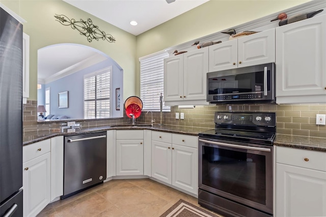 kitchen featuring white cabinetry, appliances with stainless steel finishes, decorative backsplash, and a sink