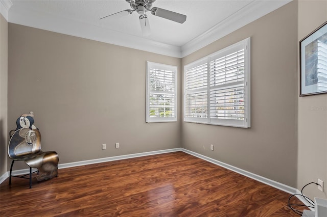 empty room featuring a ceiling fan, crown molding, baseboards, and wood finished floors