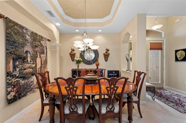 dining space with light tile patterned floors, visible vents, baseboards, ornamental molding, and a tray ceiling