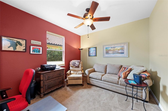 carpeted office space featuring a ceiling fan and baseboards