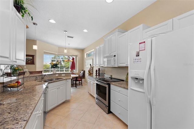 kitchen featuring light tile patterned floors, white appliances, a sink, and white cabinets