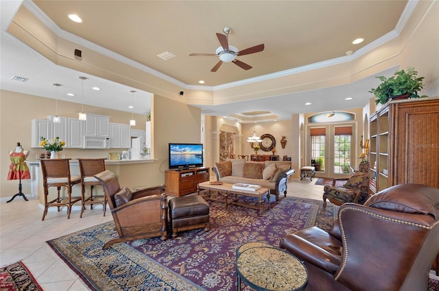 living room featuring a raised ceiling, visible vents, decorative columns, and light tile patterned floors