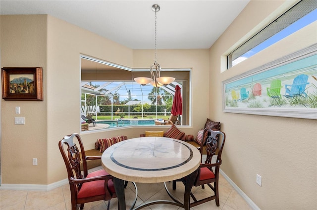 dining area with a wealth of natural light, a sunroom, baseboards, and light tile patterned floors