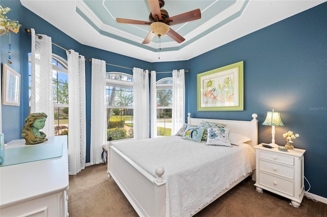 bedroom featuring a ceiling fan, baseboards, ornamental molding, carpet, and a raised ceiling