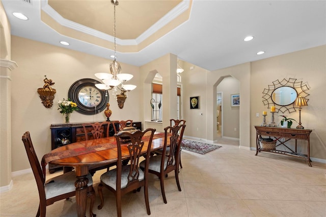 dining area featuring baseboards, arched walkways, a raised ceiling, crown molding, and recessed lighting