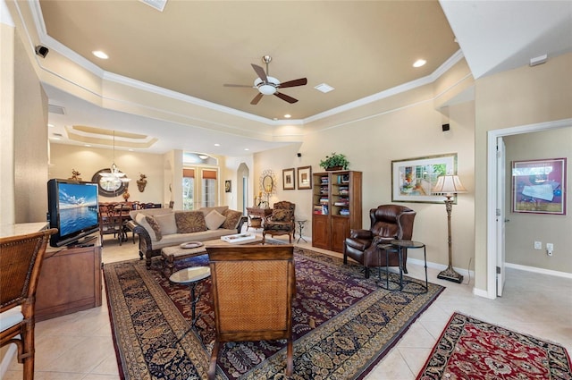 living room with a tray ceiling, crown molding, arched walkways, and light tile patterned floors