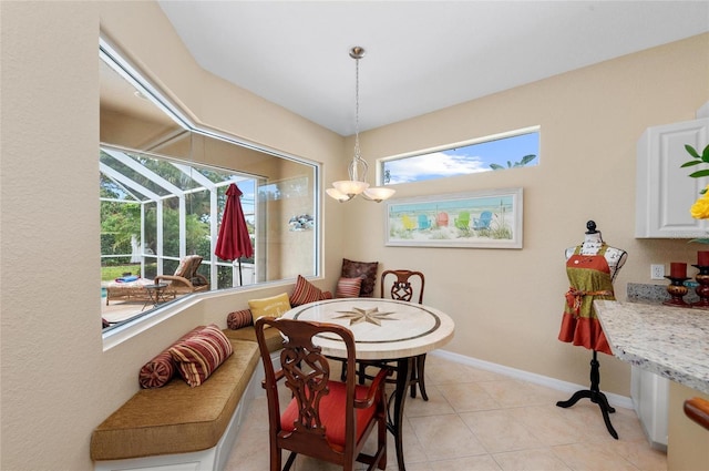 dining area featuring a sunroom, light tile patterned floors, and baseboards