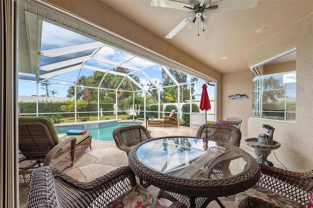 view of patio / terrace with outdoor dining space, an outdoor pool, glass enclosure, and ceiling fan