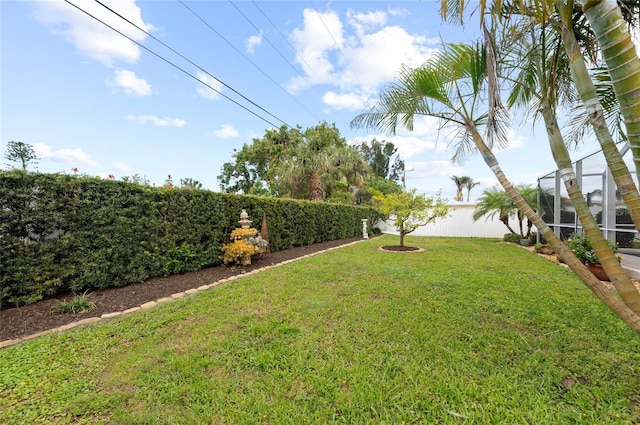 view of yard with a fenced backyard and a lanai