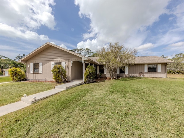 single story home featuring board and batten siding and a front lawn