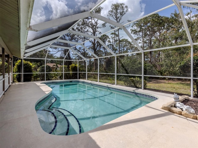 outdoor pool featuring glass enclosure and a patio