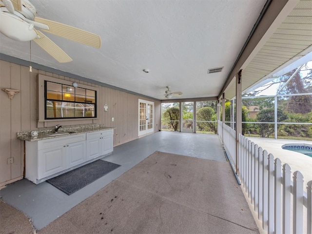 view of patio with visible vents, ceiling fan, a sink, french doors, and a lanai