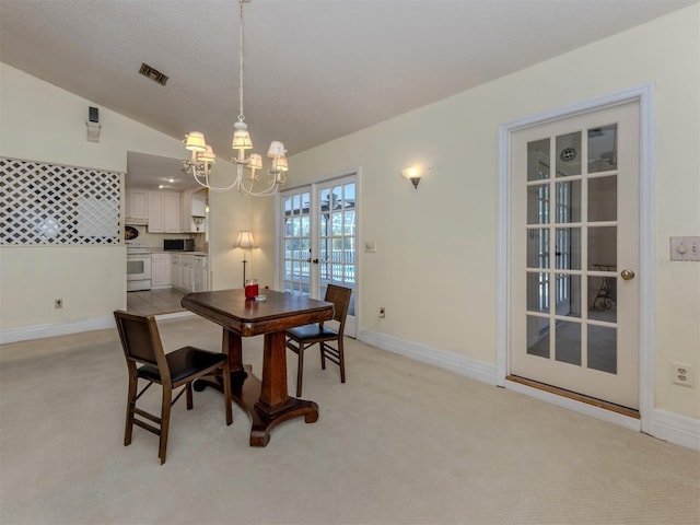 dining area featuring visible vents, light carpet, a notable chandelier, french doors, and baseboards