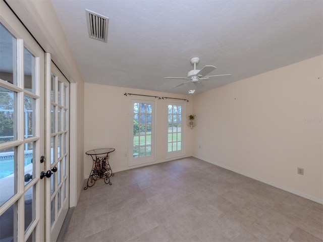 empty room featuring visible vents, french doors, baseboards, and a ceiling fan