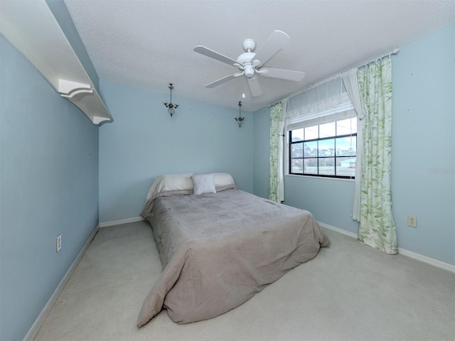 bedroom with carpet flooring, ceiling fan, a textured ceiling, and baseboards