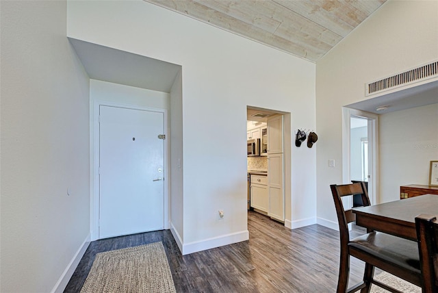 dining space featuring dark wood-style floors, baseboards, and visible vents