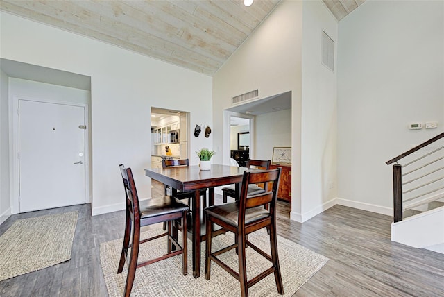 dining room featuring stairs, wood finished floors, visible vents, and baseboards