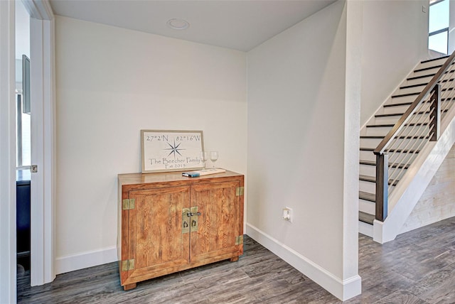 interior space with stairway, wood finished floors, and baseboards