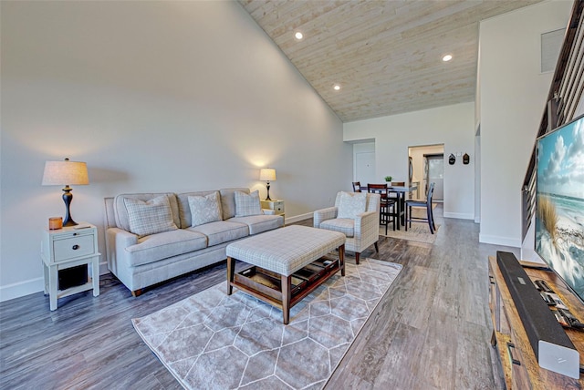 living room featuring high vaulted ceiling, recessed lighting, wood finished floors, and baseboards