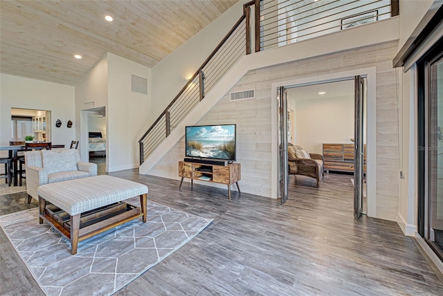 living room featuring recessed lighting, visible vents, a high ceiling, and wood finished floors