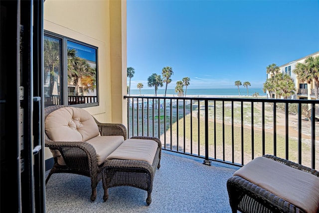 balcony featuring a view of the beach and a water view