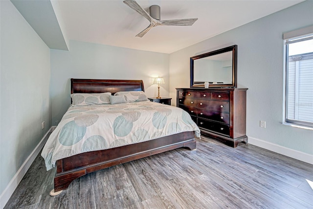 bedroom with ceiling fan, baseboards, and wood finished floors